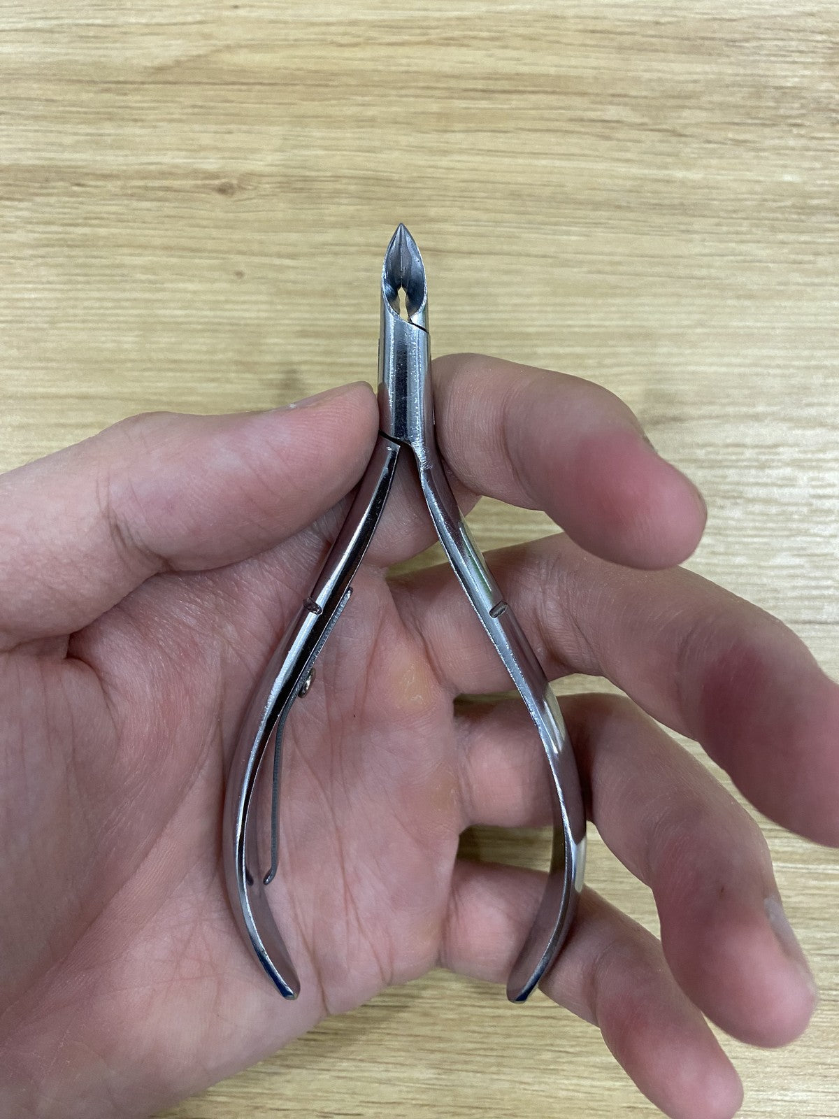 ElisNail semi-round cuticle nipper held in a hand to show its size