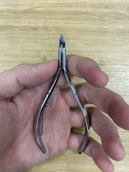 ElisNail semi-round cuticle nipper held in a hand to show its size