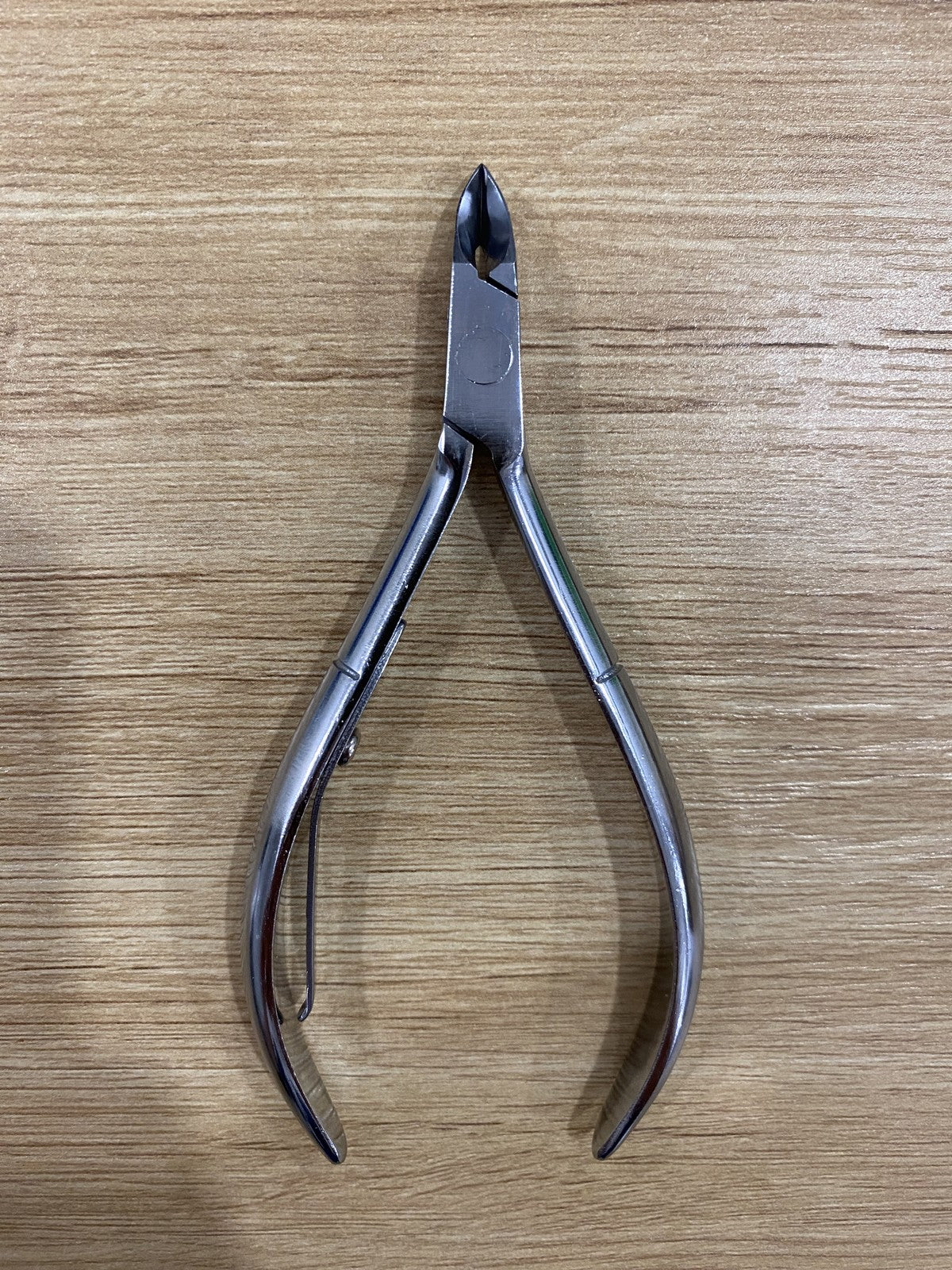 ElisNail square box joint cuticle nipper, full tool on a wooden bench