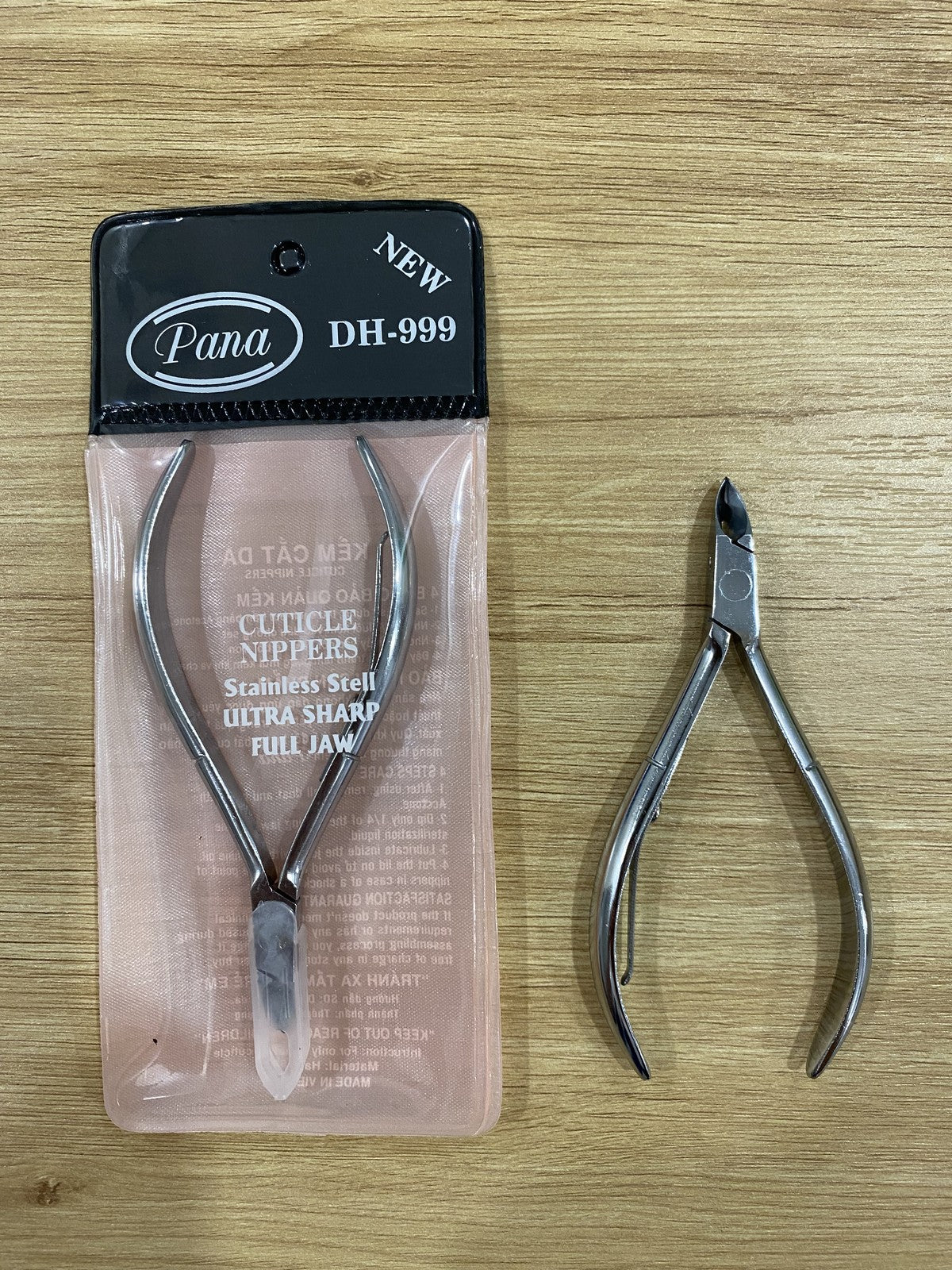 ElisNail square box joint cuticle nipper next to its sealed pouch